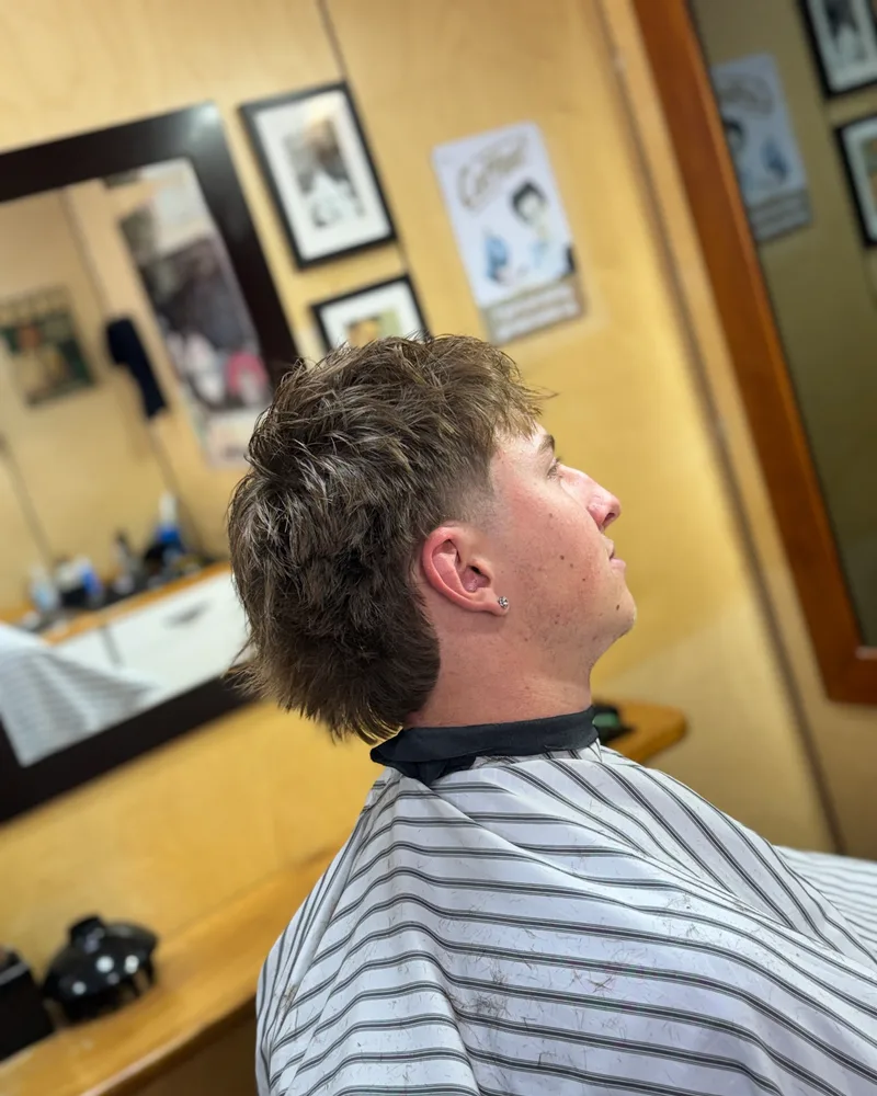 Side profile of a textured modern mullet with a faded temple and length left at the back