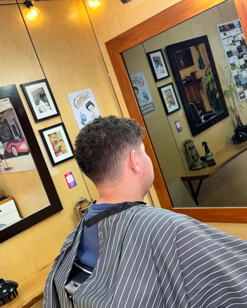 Back view of curls left on top with a low fade around the sides and neck